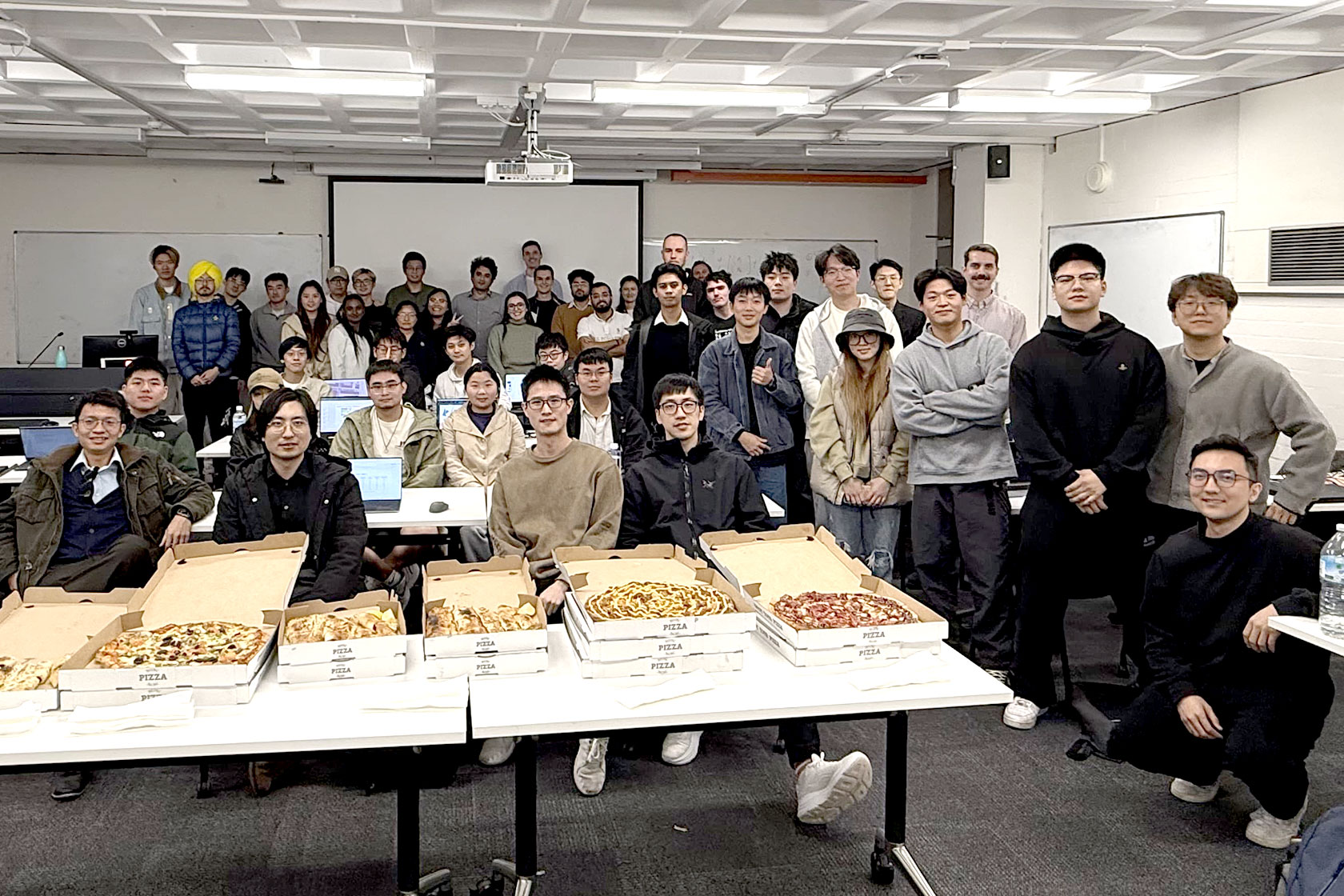 Erni poses for a photo with her University of Sydney classmates at a pizza party following their group project presentation.