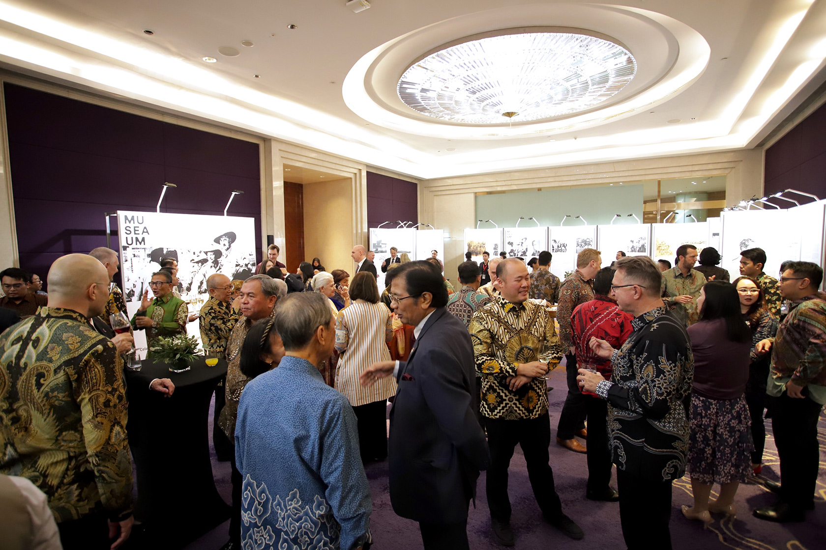 Distinguished guests engage in joyful conversations while enjoying canapés and drinks.