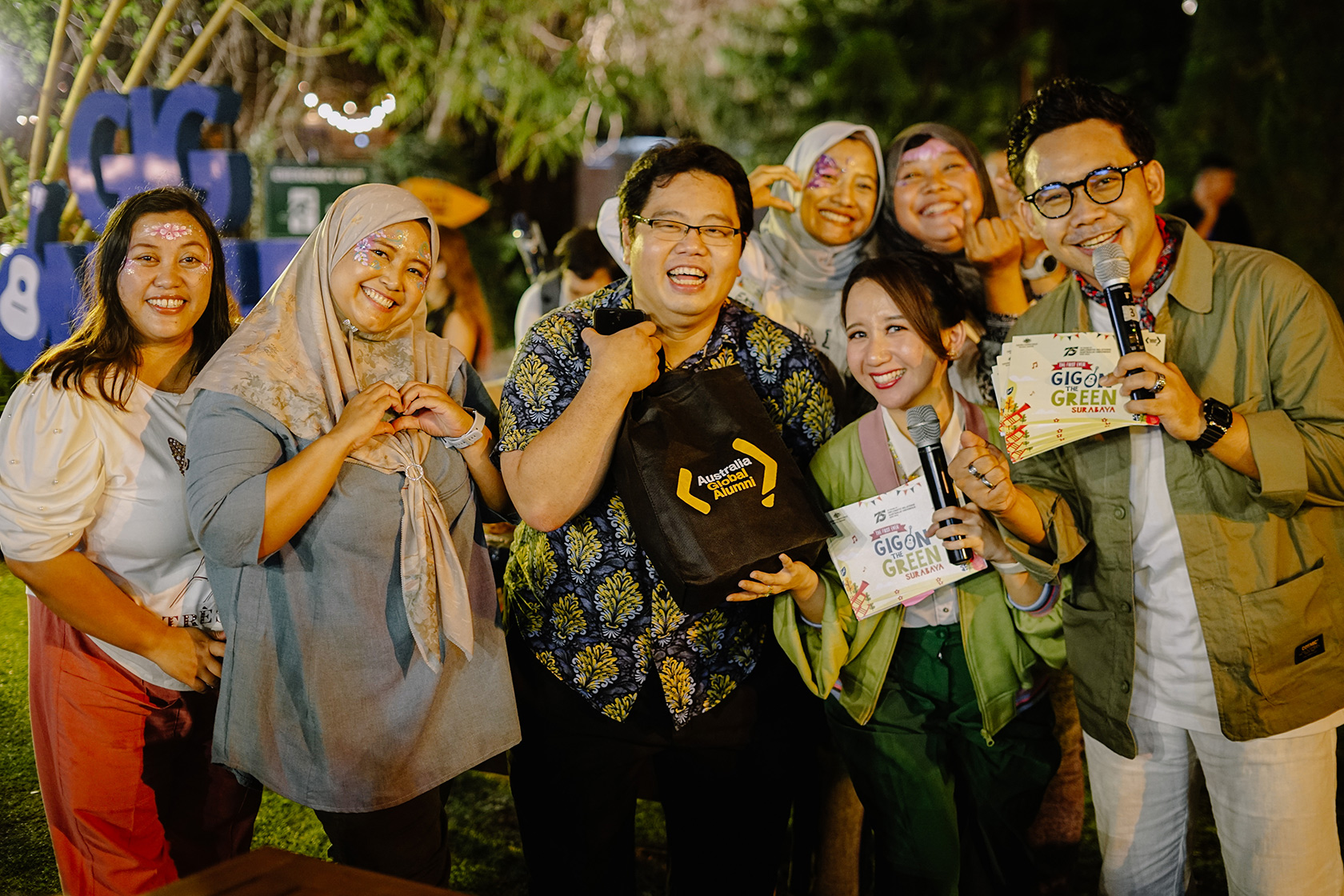 An alumnus happily shows off the merchandise he won by answering a quiz.