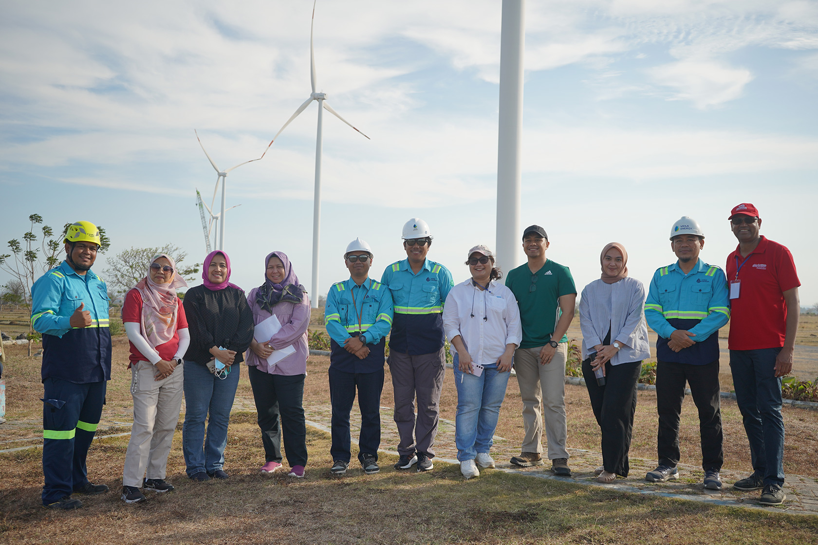 A group of participants take a photo with the Tolo 1 Wind Farm Project representatives.