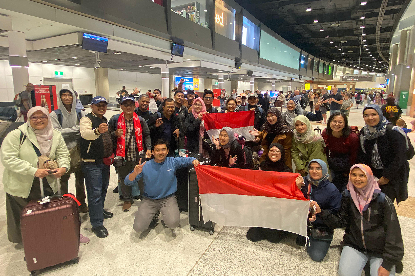 Participants excitedly take a group photo at the airport before departing for Australia.