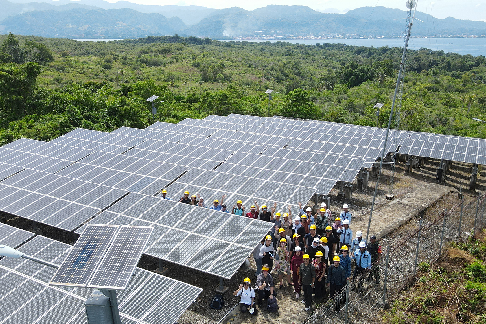 Participants pose in front of the solar panels, a renewable energy project in Mamuju, highlighting their commitment to a just energy transition.