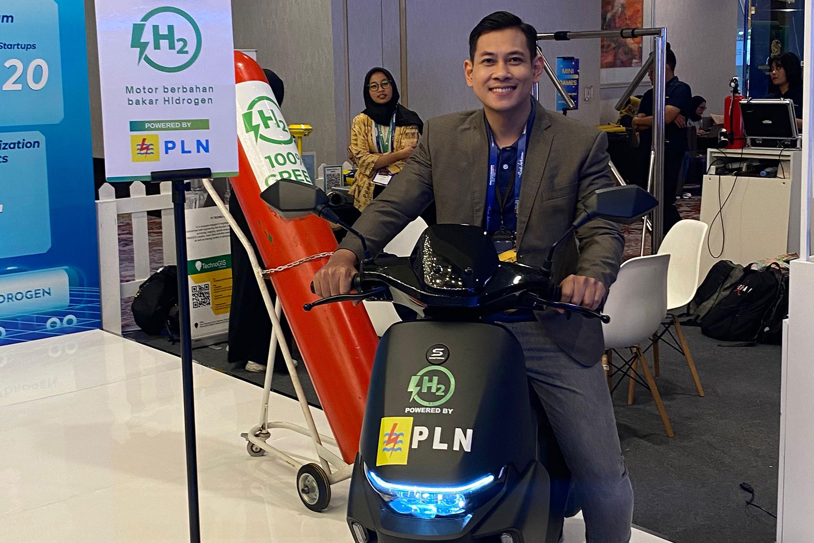 Rodzi poses for a photo with a hydrogen-powered motorcycle at the Indonesia International Motor Show 2024, held in Jakarta.
