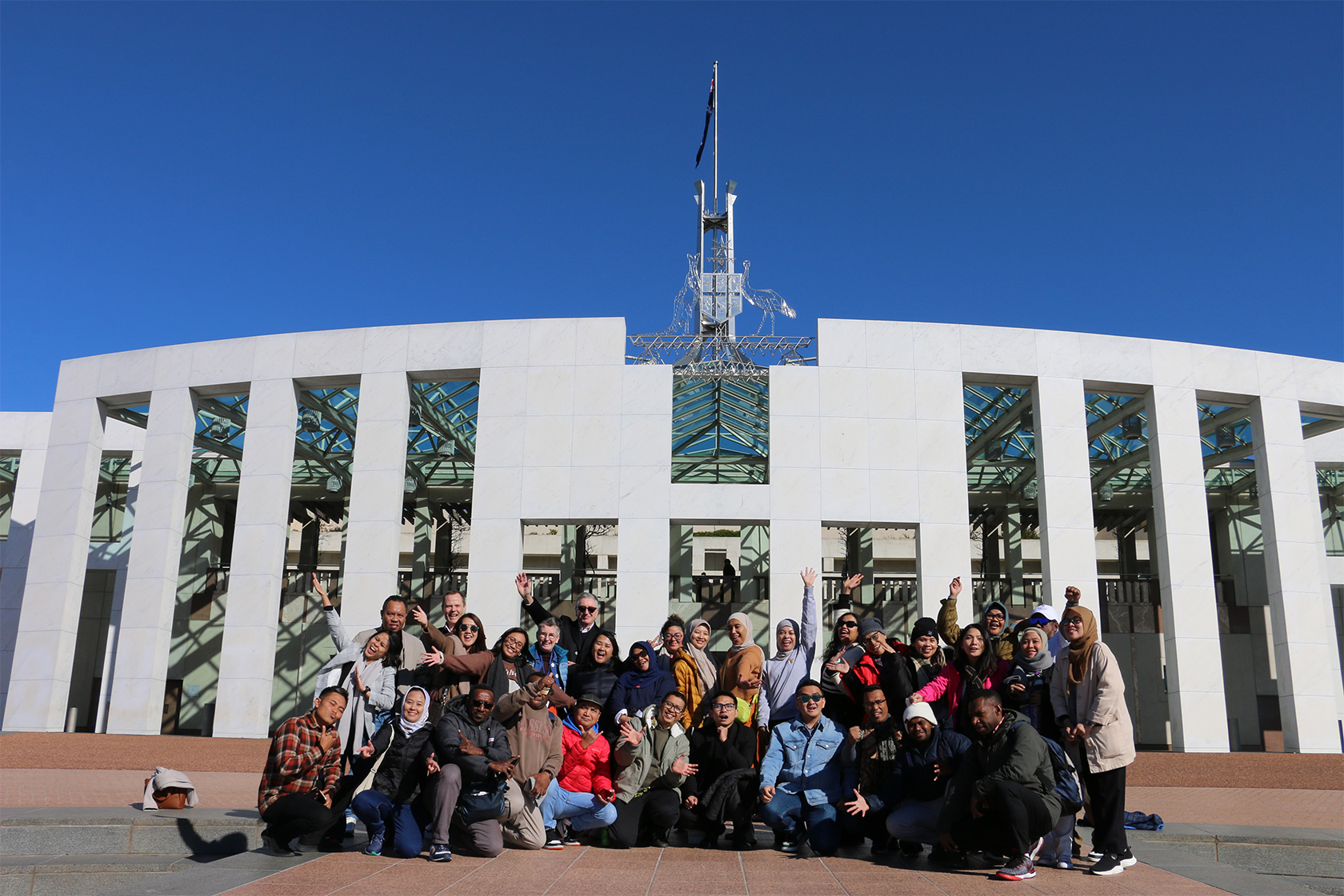 The short course participants gather in front of the Parliament House in Canberra.