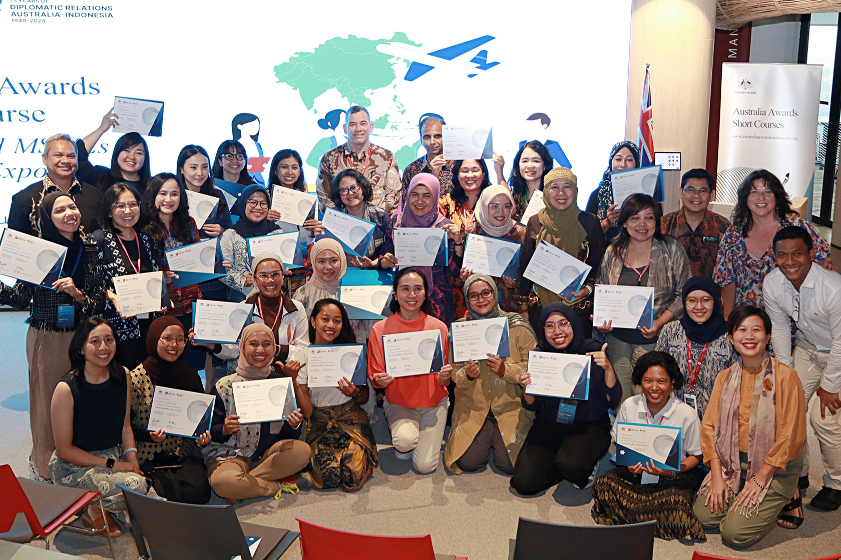 The course participants happily pose for a photo, displaying their certificates as they officially become part of the Australia Awards alumni network.