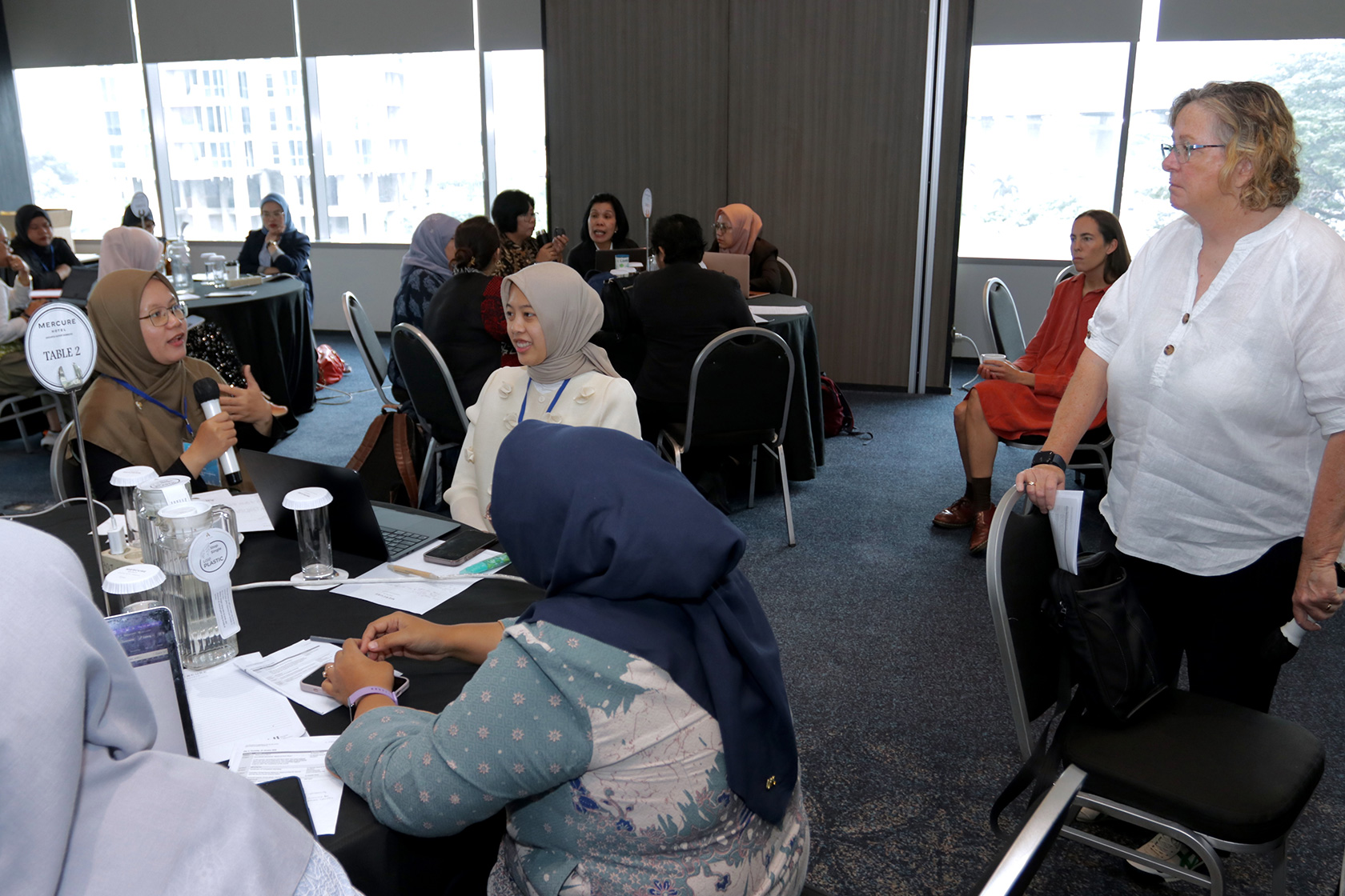 The post-course workshop is dynamic, with participants engaging in discussions with the course facilitator.