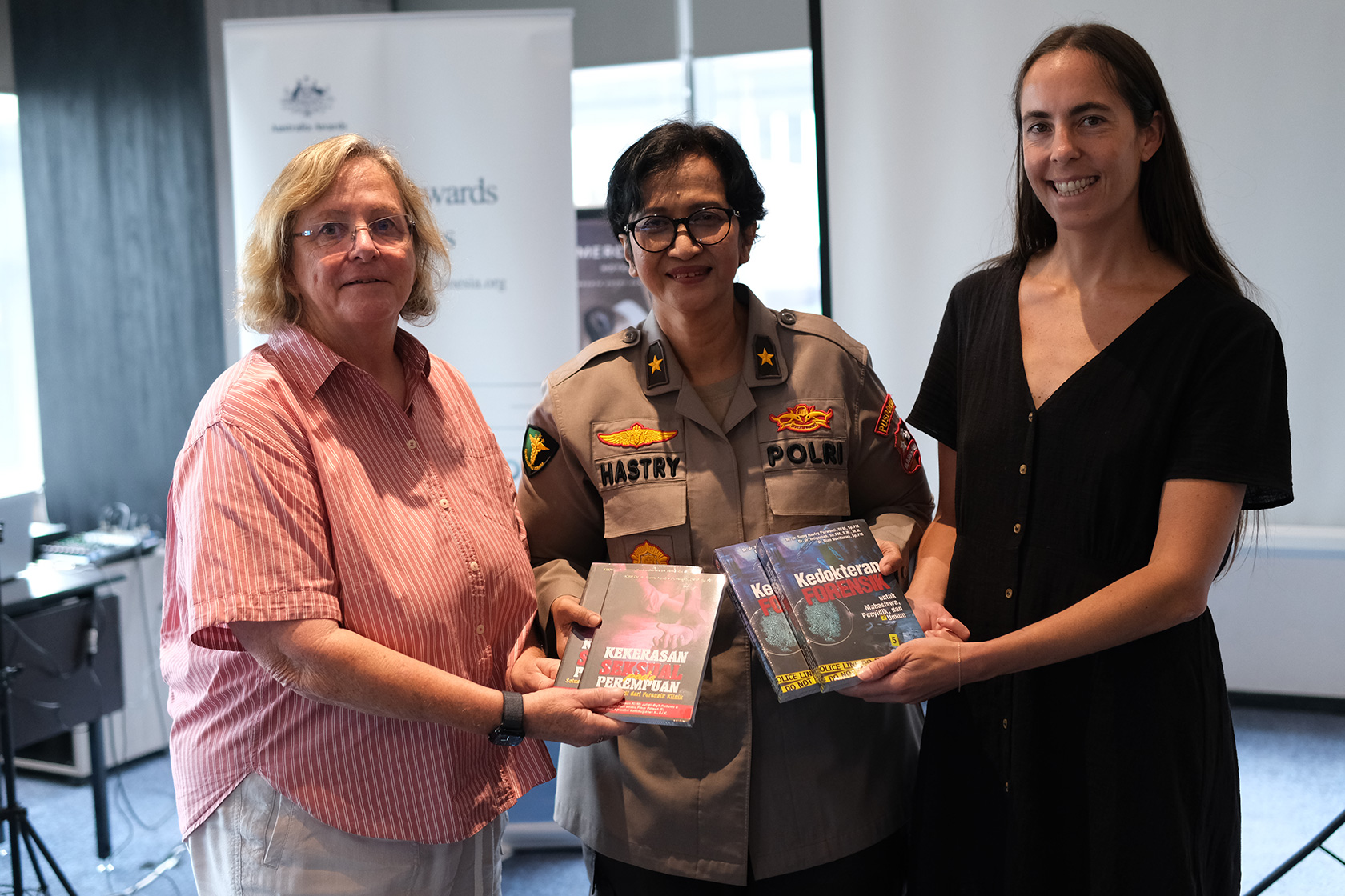 Brigadier General Dr Sumy Hastry Purwanti, Head of the Medical and Health Laboratory Division at Pusdokkes Polri, presents books on forensic studies. 