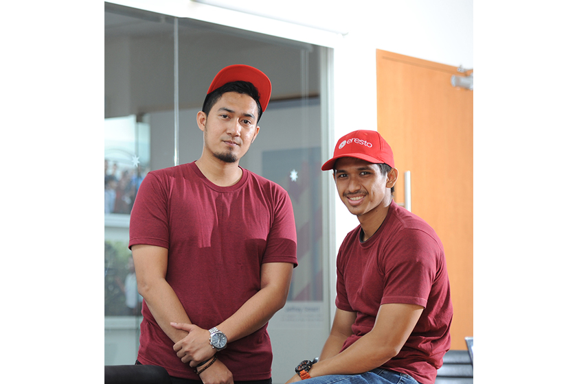 Two smiling men wearing red cap and t-shirt