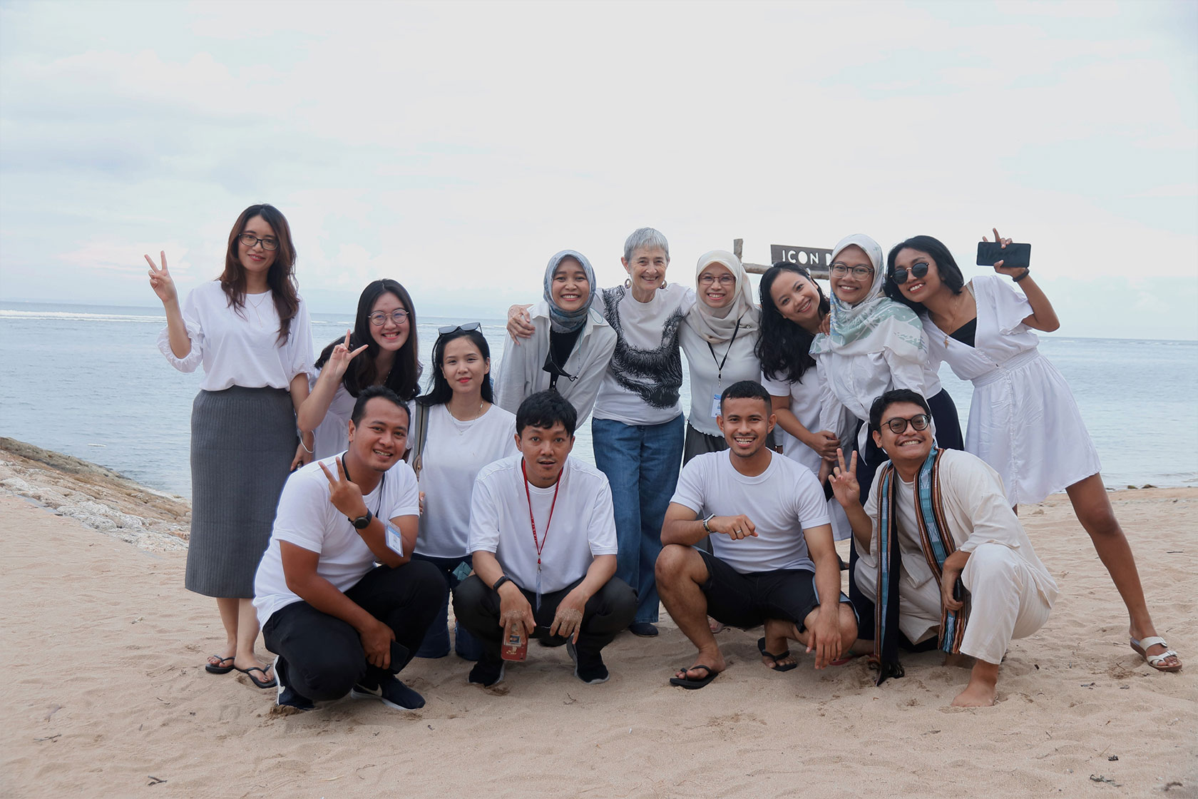 A group of Australia Awards scholars and an IALF tutor are posing together on the beach